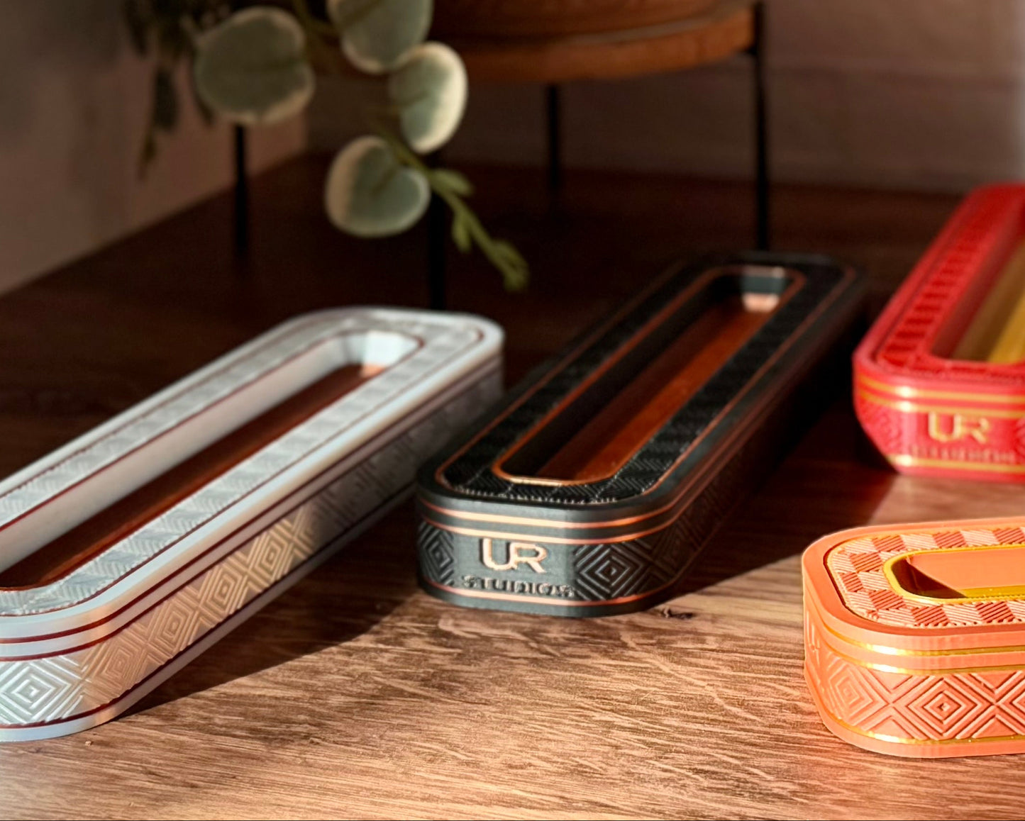 Collection of vintage-style rectangular boxes on a wooden surface with a plant in the background.