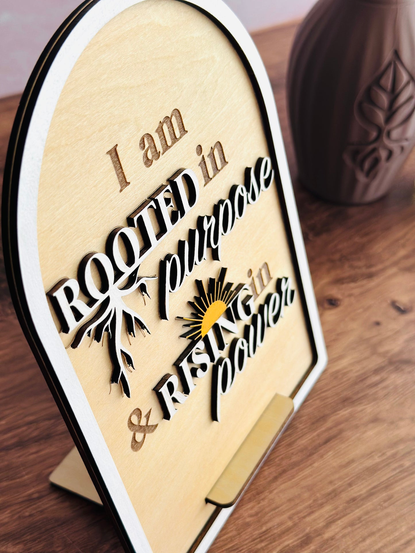 Decorative sign with motivational quote on a wooden surface