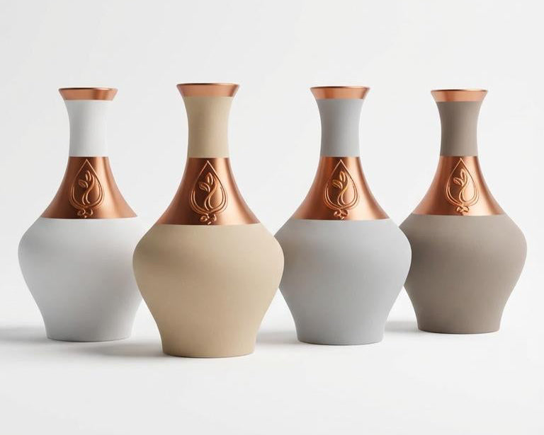 Four vases with copper accents on a white background